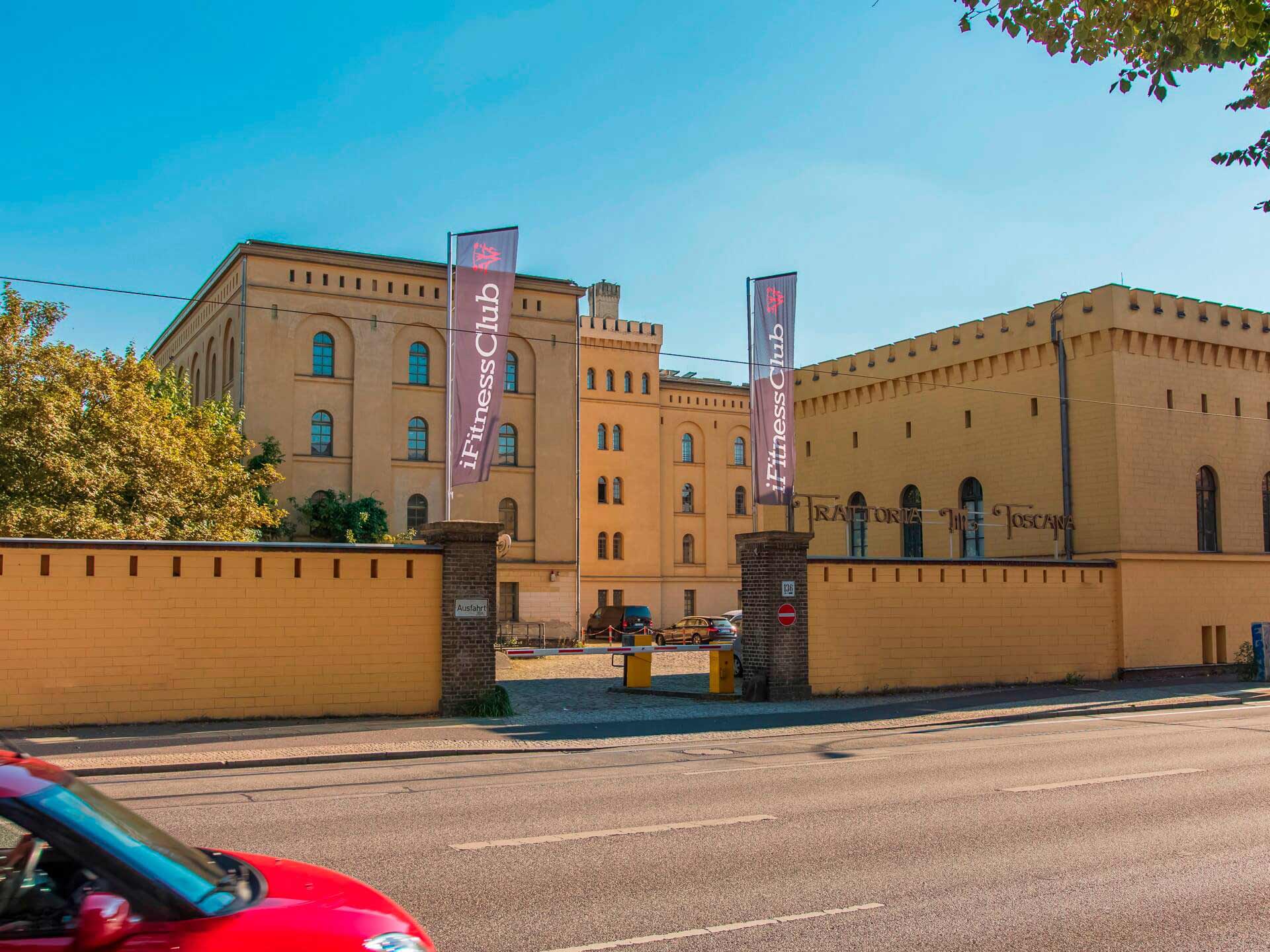 Ein historisches Gebäude aus gelbem Backstein mit Fitnessclub-Schildern.
